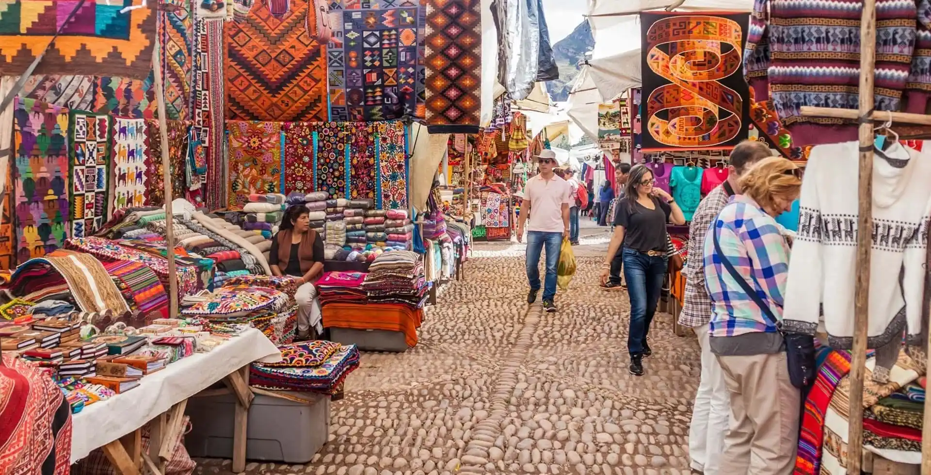 Colorful artisan stalls at Pisaq Market selling handmade Andean textiles, crafts, and traditional souvenirs in the Sacred Valley, Peru.